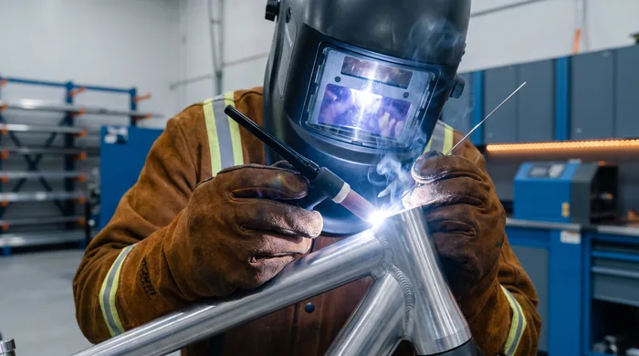 Certified welder performing a precise TIG weld on an aluminum frame at DavFab